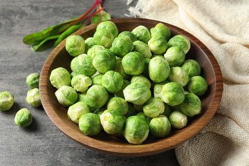 Bowl of fresh Brussels sprouts and napkin on grey table