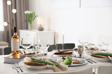 Festive Passover table setting with Torah at home. Pesach celebration