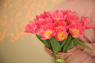Girl holding spring tulips on blurred background, closeup with space for text. International Women's Day