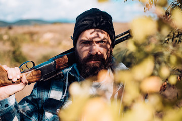 Hunter with shotgun gun on hunt. Man holding shotgun.
