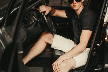 Young man sitting in his car.