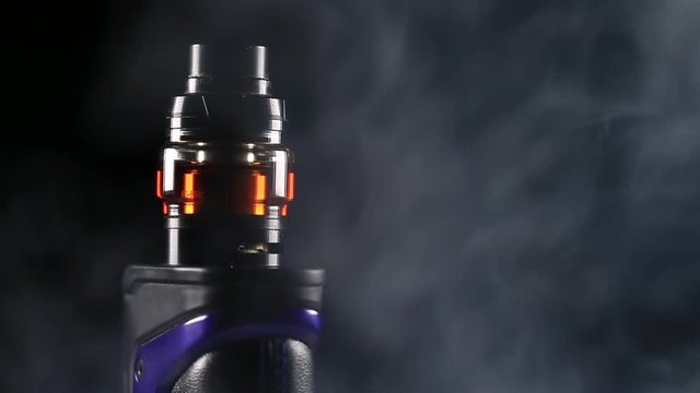 Spinning Closeup of Vape Mod with Black Background and Clouds of Vapor.