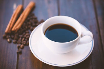Cup of black coffee on wooden table, hot drink