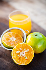 Tangerine orange fruit and juice on wooden table