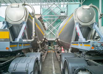 Tanker storage truck loading sugar in storage silo at manufacturing factory. Business industrial concept.