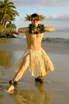 This Hawaiian Hula Dancer hits a strength pose on the beach in Maui, Hawaii. 