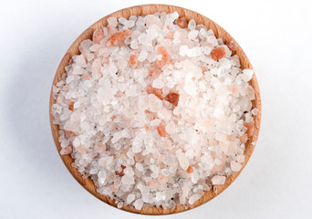 Himalayan pink salt  in wooden bowl isolated on white background.