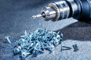Closeup construction building tools, electric screwdriver and screws. Repair background.