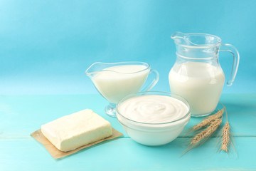 Dairy products. Cottage cheese, cheese, milk and kefir on blue wooden background with copy space.