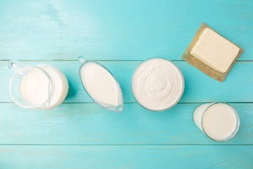 Dairy products. Cottage cheese, cheese, milk and kefir on blue wooden background with copy space.