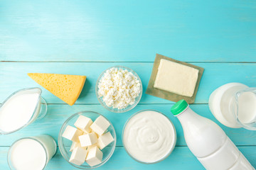 Dairy products. Milk, kefir, cottage cheese, cheese, sour cream, butter, cream and eggs on blue...
