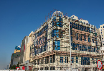 Building under construction is encased in scaffolding in Doha