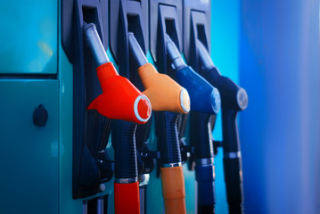 Gas station close-up with colored fuel hoses.