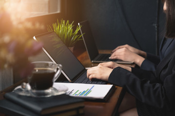Two Businesswoman working and communicating while sitting at the office desk together.