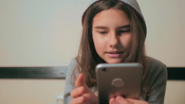 online shopping online retail service based . little teen girl in the hood writes a message chatting in social media messenger. children technology and communication concept. lifestyle teenage girl