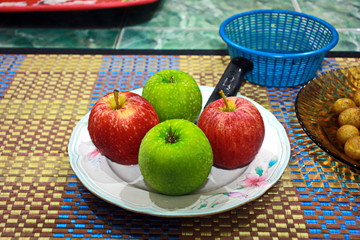 apples in a bowl on wooden table