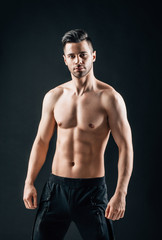 Fototapeta na wymiar Sexy muscular shirtless man posing on black background