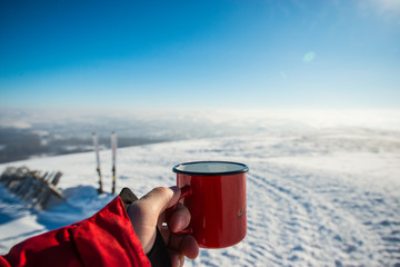 after skiing, it is a great pleasure to drink hot coffee from a red mug