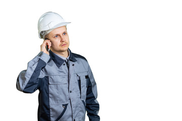 An engineer in a white helmet talking on the phone on a white background. He listens to the boss or new tasks for the repair of construction. isolated