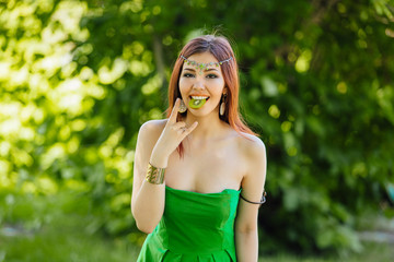 Beautiful young asian woman with slice of kiwi in mouth