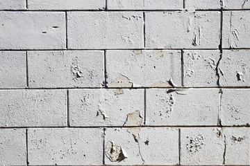 Rough white stone wall with peeling paint grunge vintage texture background
