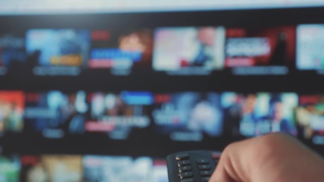smart tv. online video streaming service. with apps and lifestyle hand. Male hand holding remote the control turn off smart tv. man hand controls holding remote. concept internet online cinema