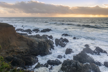 Fototapeta na wymiar Rugged Coastline with dramatic sky in distance. Montara, San Mateo County, CA
