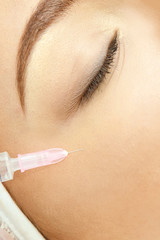 Woman face cosmetology treatment. Biorevitalization skin therapy. Doctor insert filler. Girl clinic...