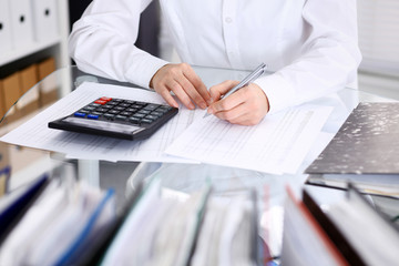 Unknown bookkeeper woman or financial inspector  making report, calculating or checking balance,...