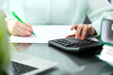 Bookkeeper or financial inspector  making report, calculating or checking balance. Audit and tax service concept. Green colored image background 