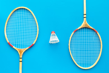 Badminton concept. Badminton rackets and shuttlecock on blue background top view pattern