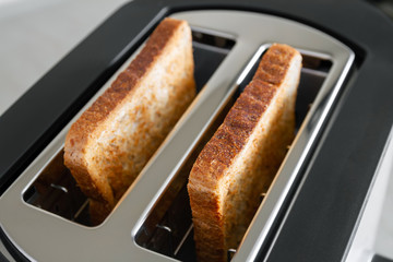 Healthy fashion food of breakfast. Toast in a toaster. Toaster with tasty breakfast toasts on the table