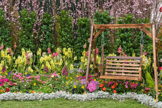Wooden swing seat in flower garden