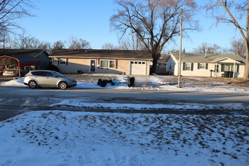 house with snow and trash in front