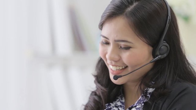 happy smiling call center operator answering phone using headphone