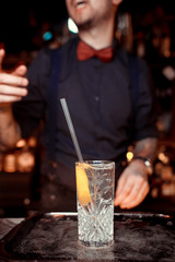 Expert barman is making cocktail at night club.