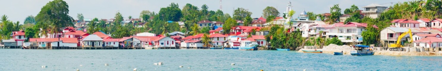 Fototapeta na wymiar Red and white village at Tual, Kei Kecil island, Moluccas. A colorful slum called Kampung Merah Putih, colors of Indonesia national flag. High resolution panorama.