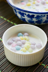 Color of Rice Dumpling in Coconut Milk (Bua Loy) in white bowl on wooden table for served in party. Famous dessert in Thailand. Sweet and delicious food.