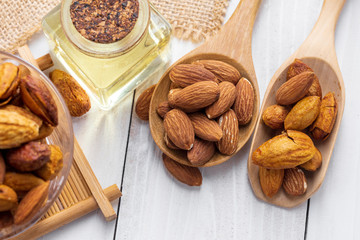 Almonds in a black bowl against dark rustic wooden background