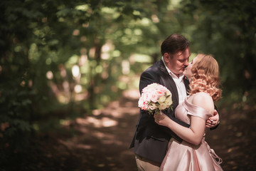 bride and groom dancing in the forest background and sunlight