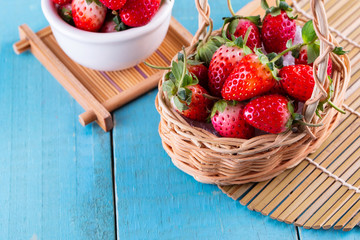 Fresh strawberries in a bowl on wooden table