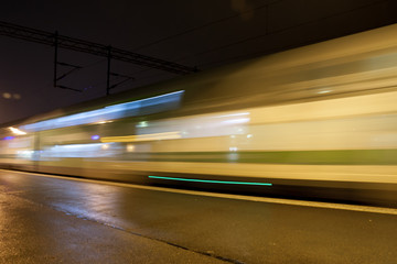 Obraz na płótnie Canvas Train in motion on the station at night, long exposure photo.