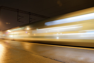 Fototapeta na wymiar Train in motion on the station at night, long exposure photo.