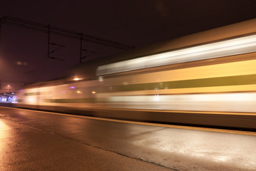 Fototapeta na wymiar Train in motion on the station at night, long exposure photo.