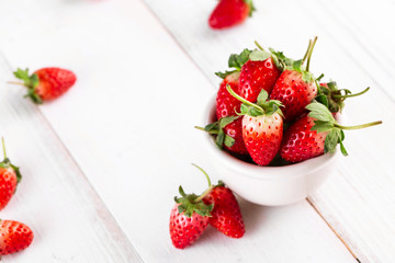Fresh strawberries in a bowl on wooden table