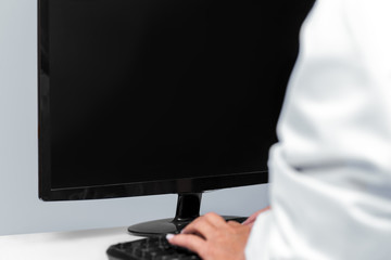 Ärztin sitzt vor einem Monitor, Textfreiraum für Telemedin oder e-health
