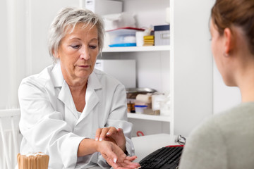 Ärztin beim Puls messen, Demonstration und Hilfestellung für Palpation