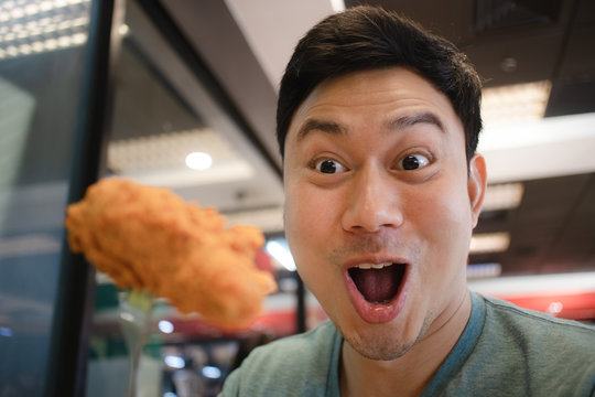 Funny Face Asian Man Eat Fried Chicken.