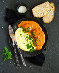 Meatballs in creamy tomato sauce with mashed potatoes.