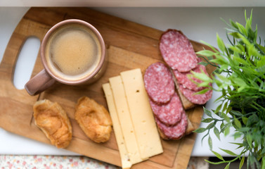 coffee mug, salami, cheese slices, mini croissants,